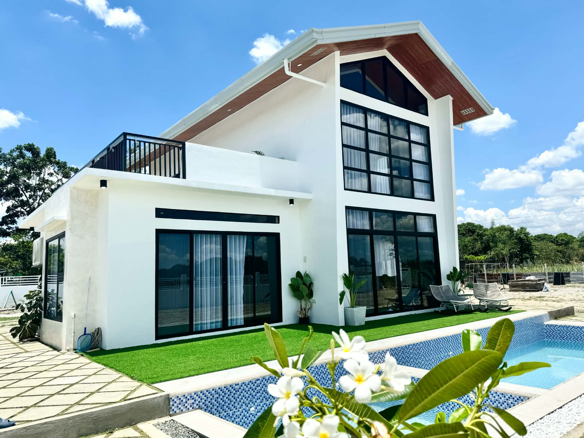 Unaltered Casa Bermuda exterior photograph: contemporary white home, glass façade and outdoor swimming pool